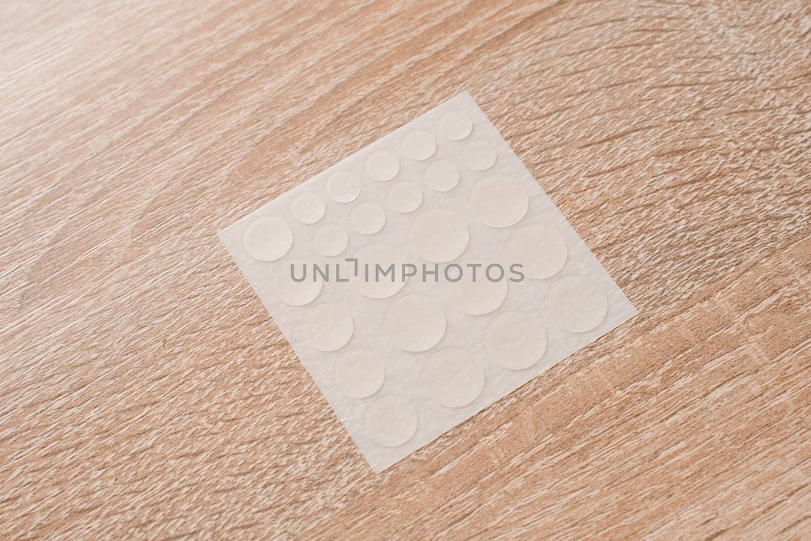 Set of round patches for acne on wooden background. Acne patches for the treatment of pimple and rosacea close-up. Facial rejuvenation cleansing cosmetology. by Rabizo