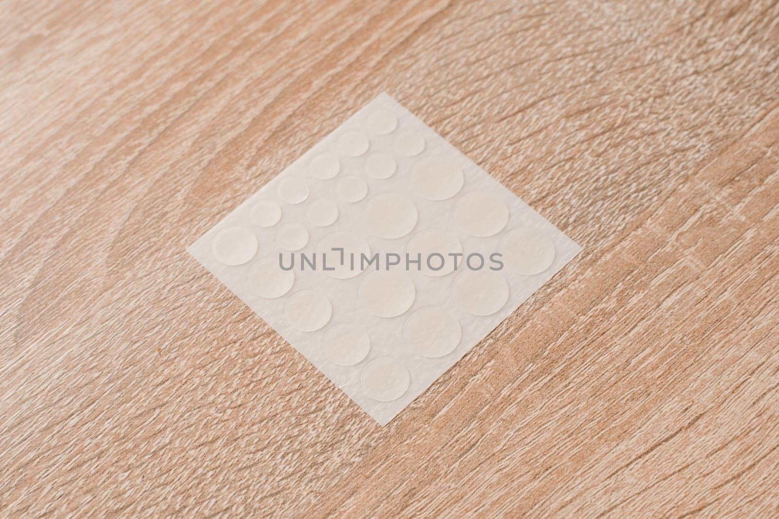 Set of round patches for acne on wooden background. Acne patches for the treatment of pimple and rosacea close-up. Facial rejuvenation cleansing cosmetology. by Rabizo