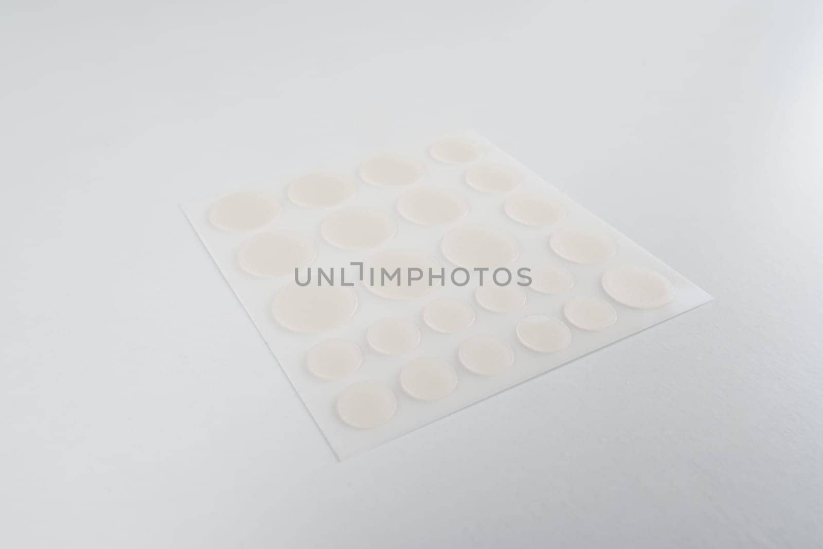 Set of round patches for acne on white background. Acne patches for the treatment of pimple and rosacea close-up. Facial rejuvenation cleansing cosmetology. by Rabizo