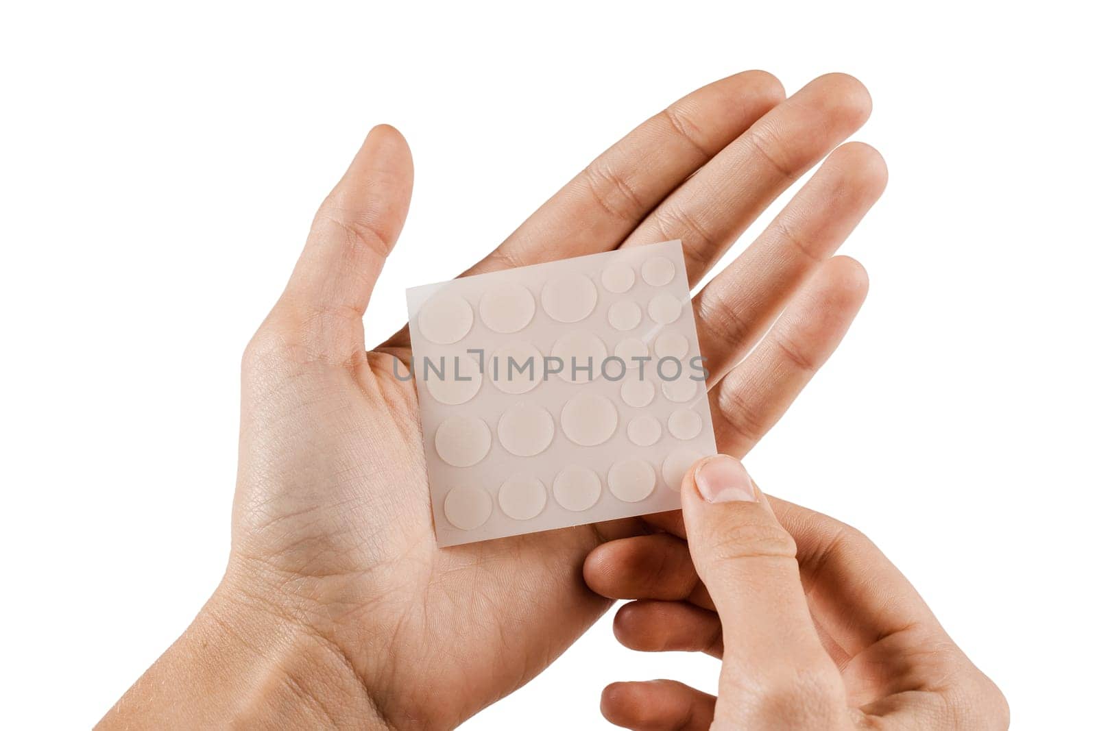 Set of round patches for acne in hands on white background. Acne patches for treatment of pimple and rosacea close-up. Facial rejuvenation cleansing cosmetology. by Rabizo