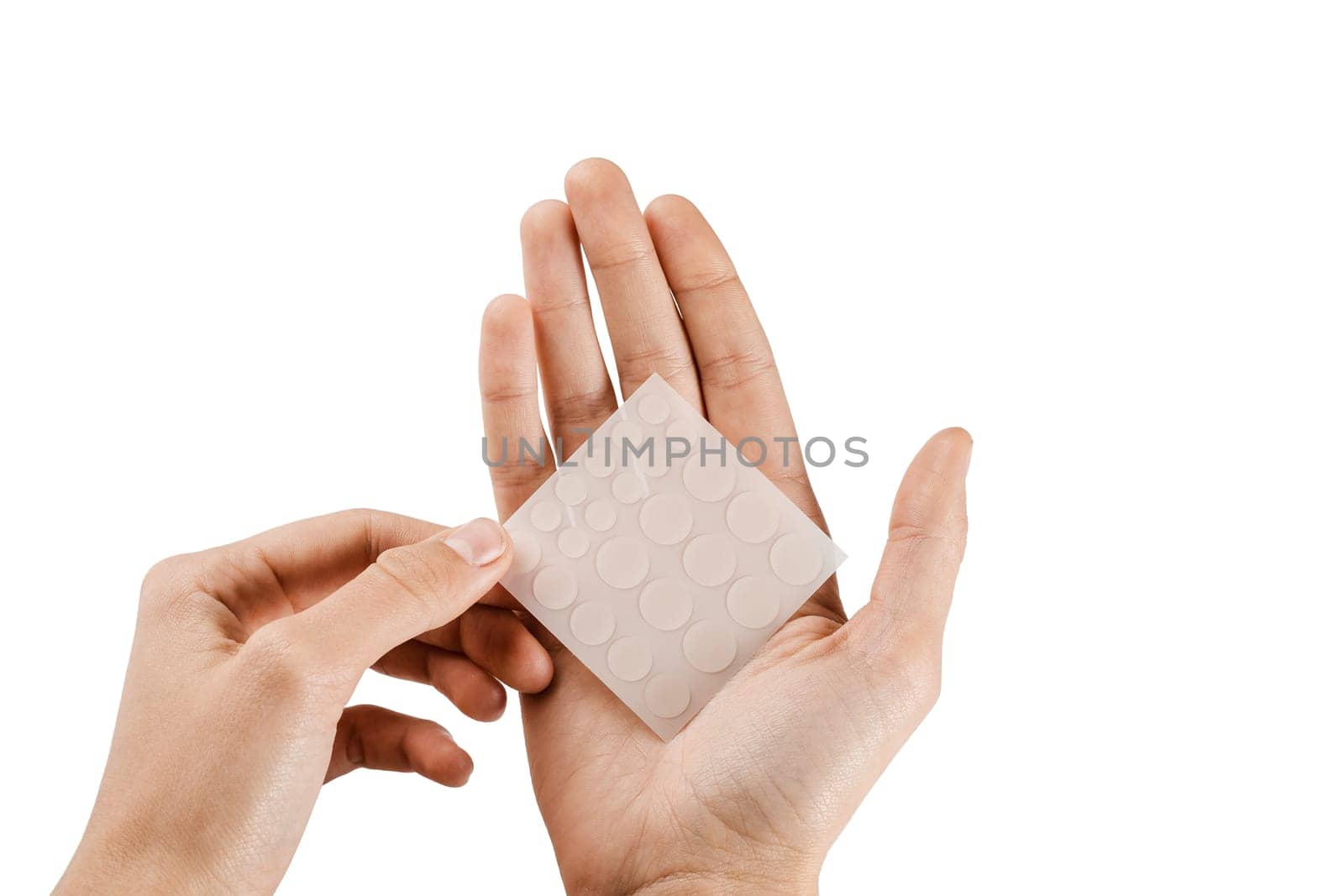 Set of round patches for acne in hands on white background. Acne patches for treatment of pimple and rosacea close-up. Facial rejuvenation cleansing cosmetology