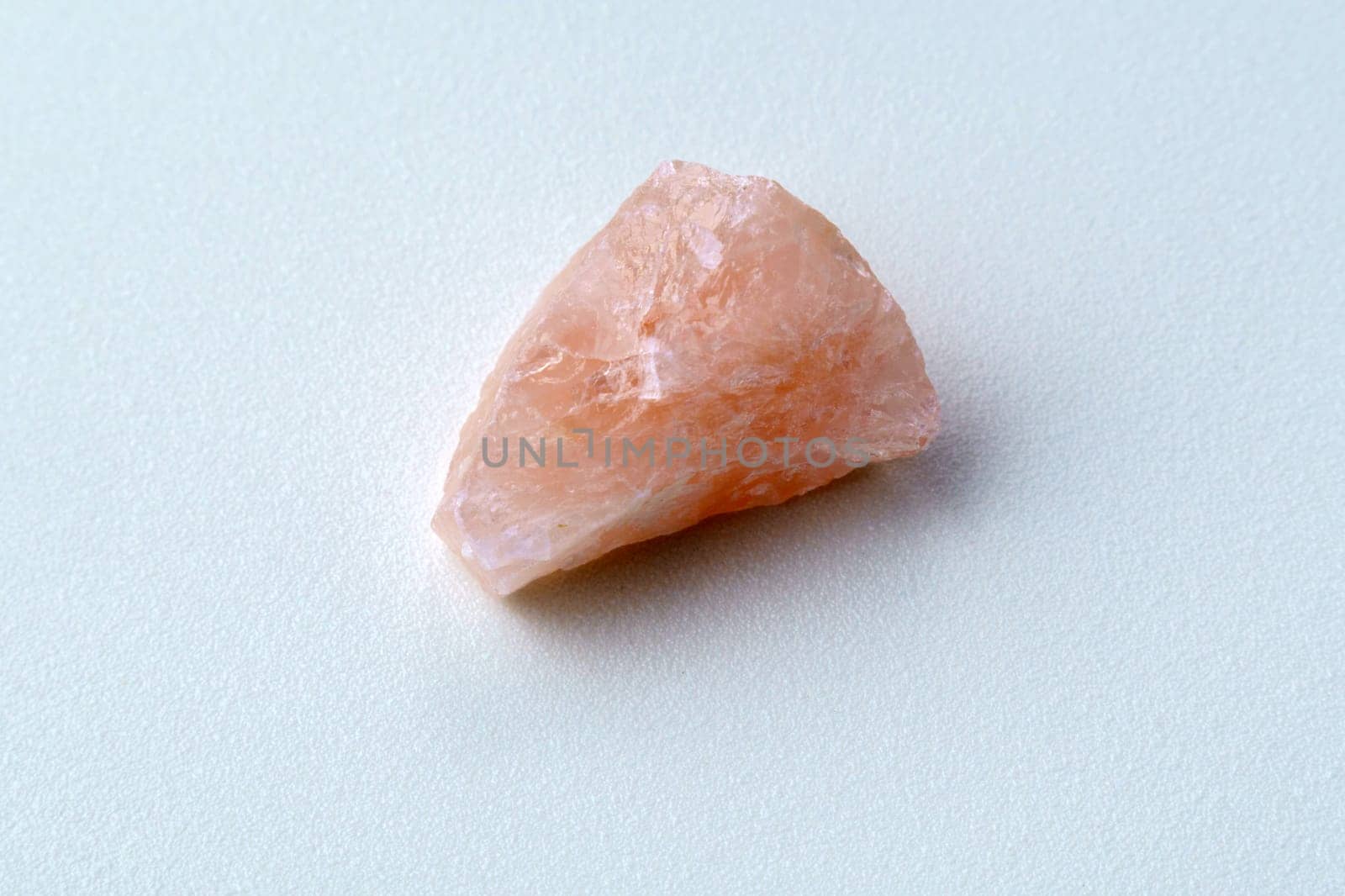 Rose quartz, stone silicate mineral. Rough, uncut, pinkish color isolated white background