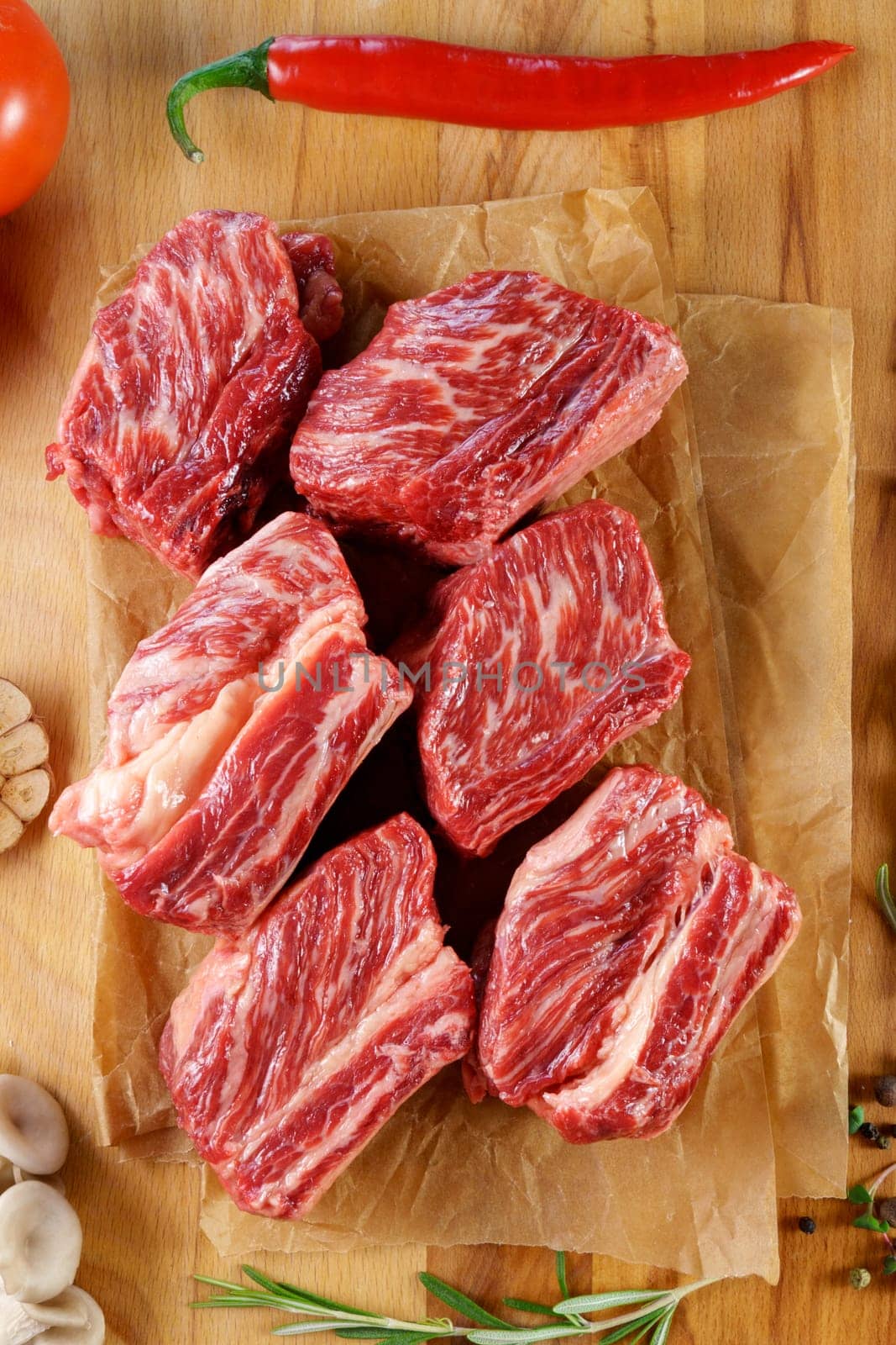 Raw steak on wooden background, raw meat for cooking steak, spices. Vertical photo