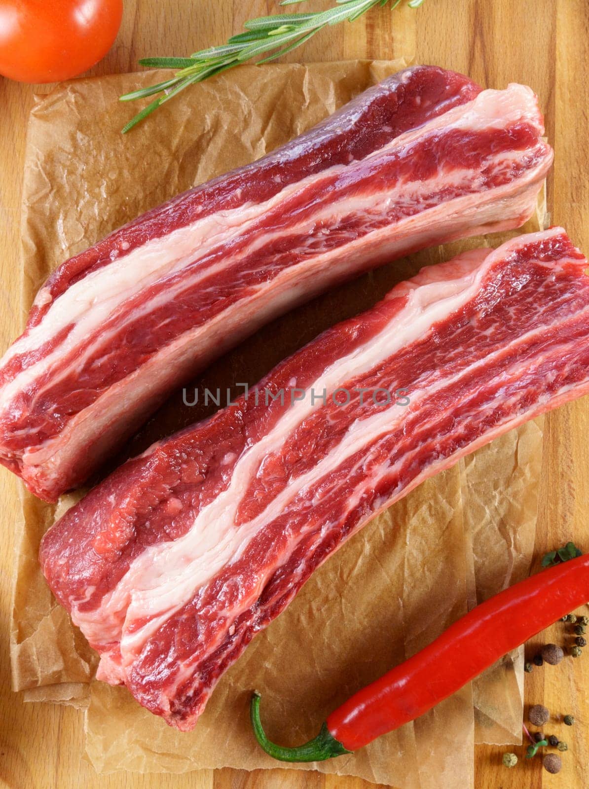 Raw cowboy steak on wooden background, prime rib eye on bone. Vertical photo