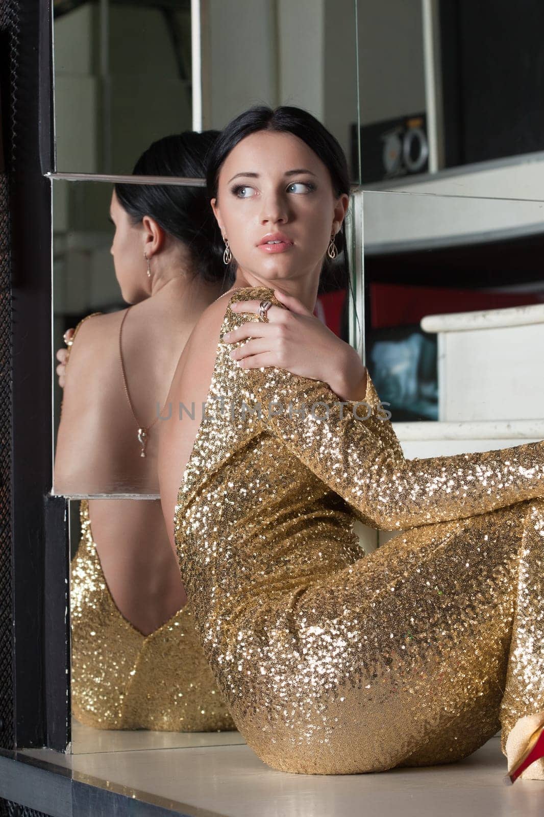 Beautiful young woman portrait in gold dress on stairs