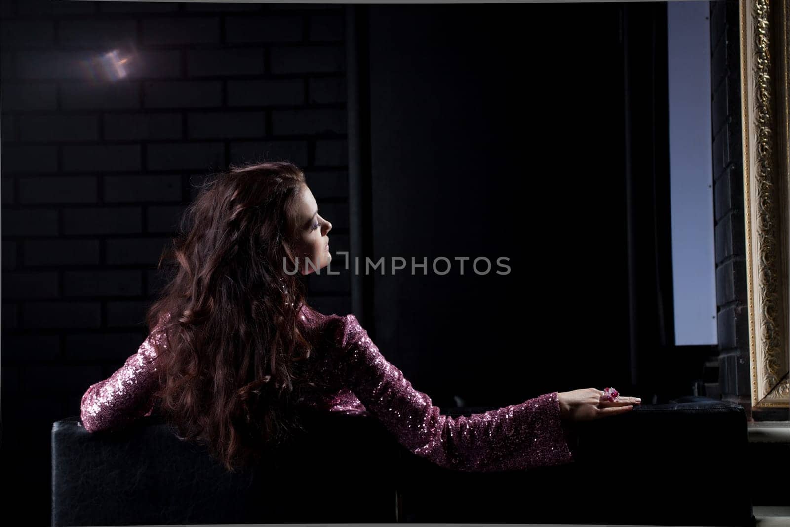 young brunette woman relax on black sofa in nightclub