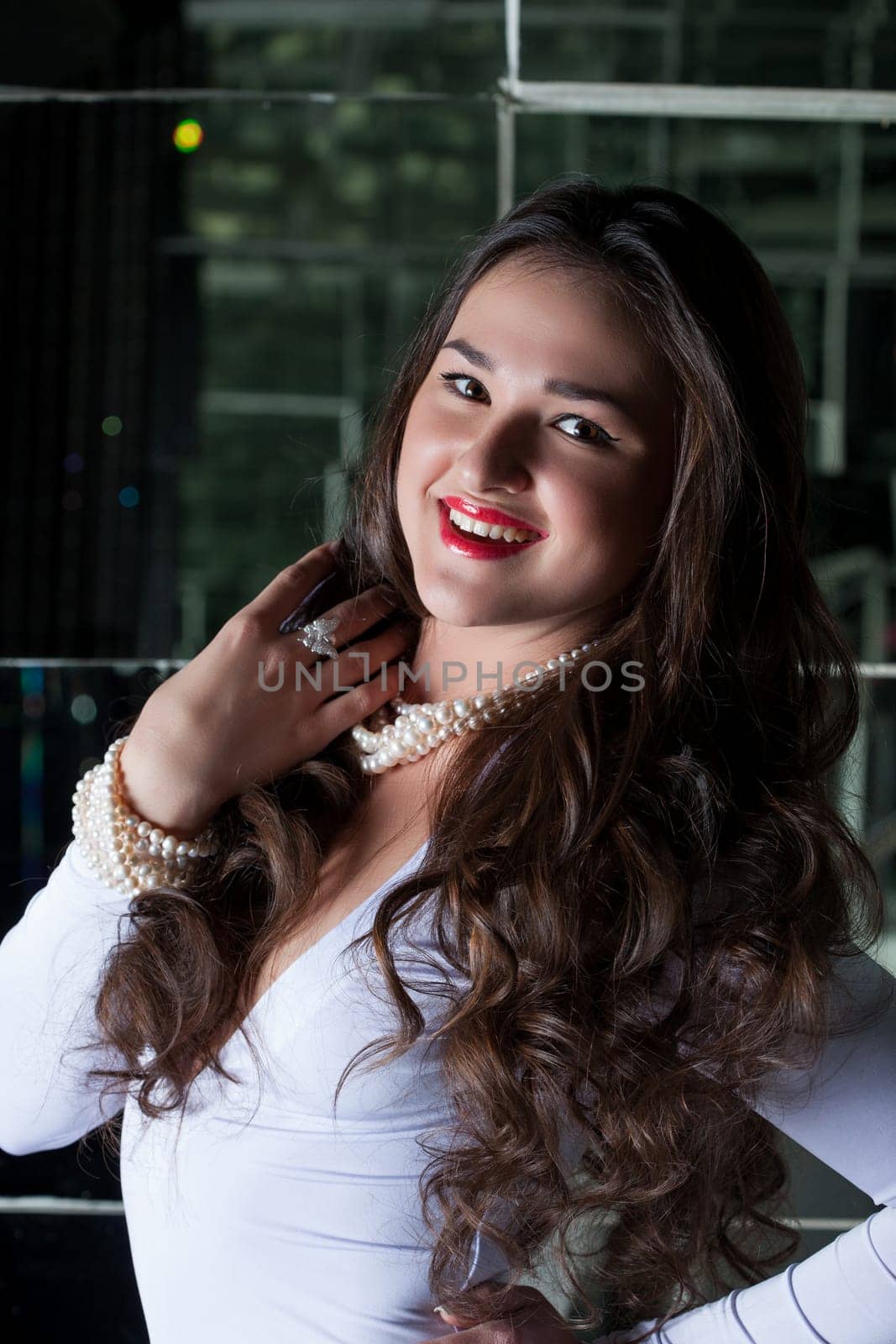 Image of beautiful smiling brunette in white dress, close-up