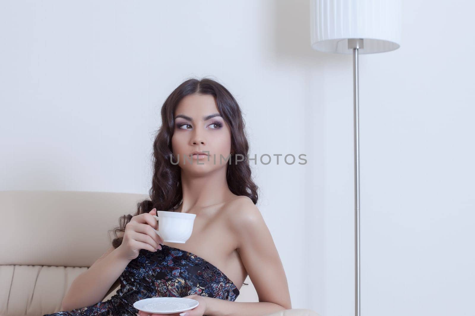 Portrait of brunette woman drinking coffee in living room