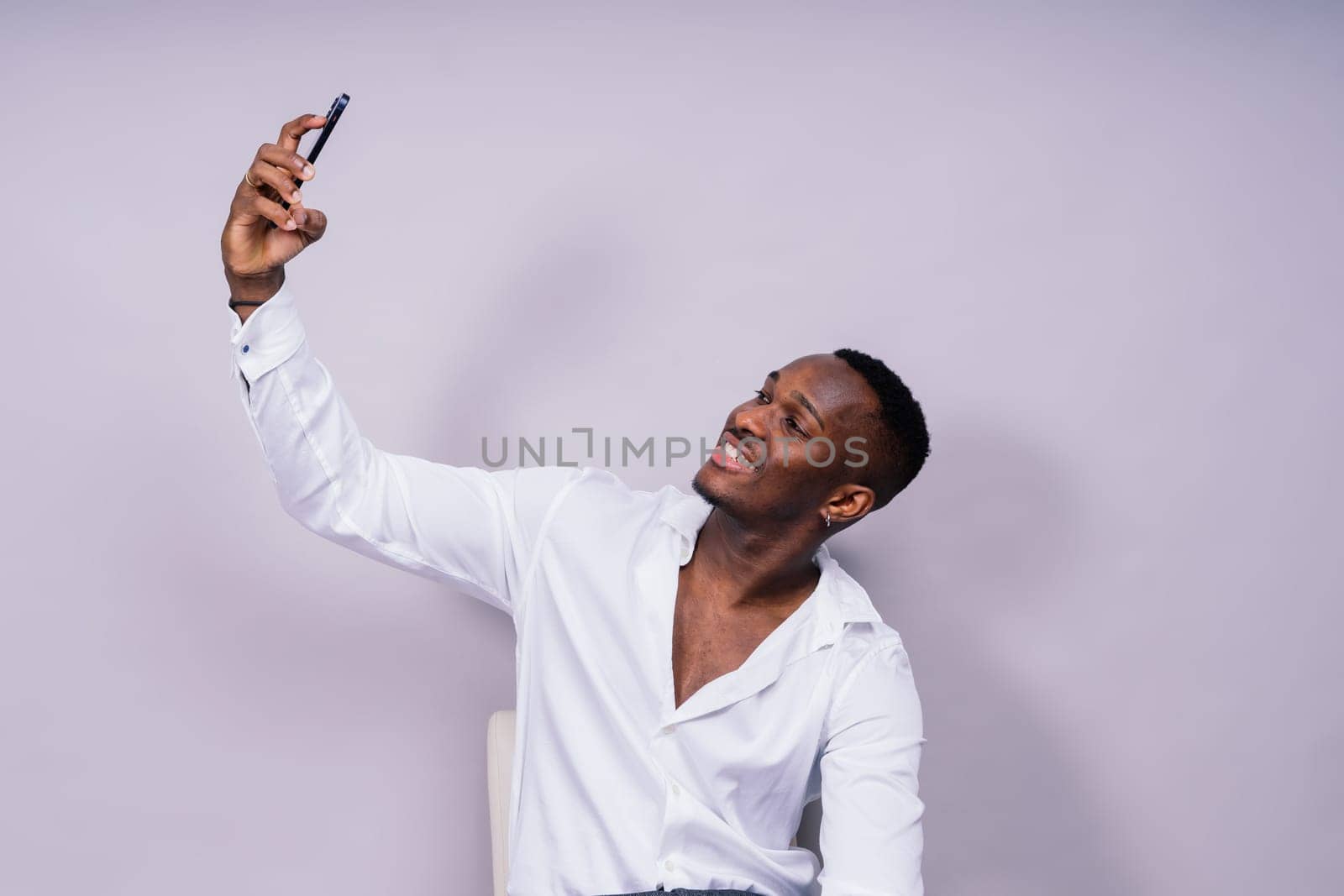 Handsome excited young african business man with mobile phone isolated over gray background by Zelenin