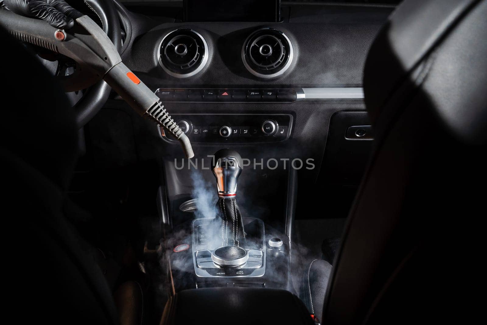 Steam cleaning of gearbox and dashboard in car. Vaping steam. Cleaning individual elements of black leather interior in auto. Creative advert for auto detailing service. by Rabizo