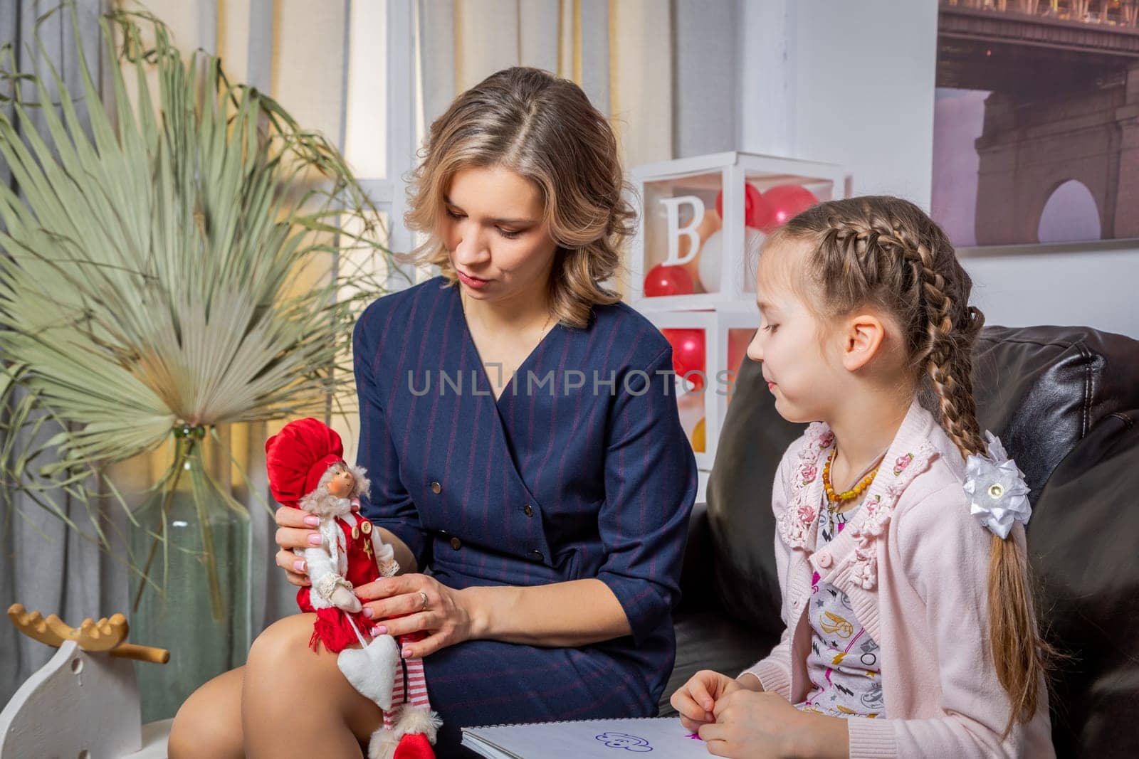 The girl psychologist plays a puppet character game with the child