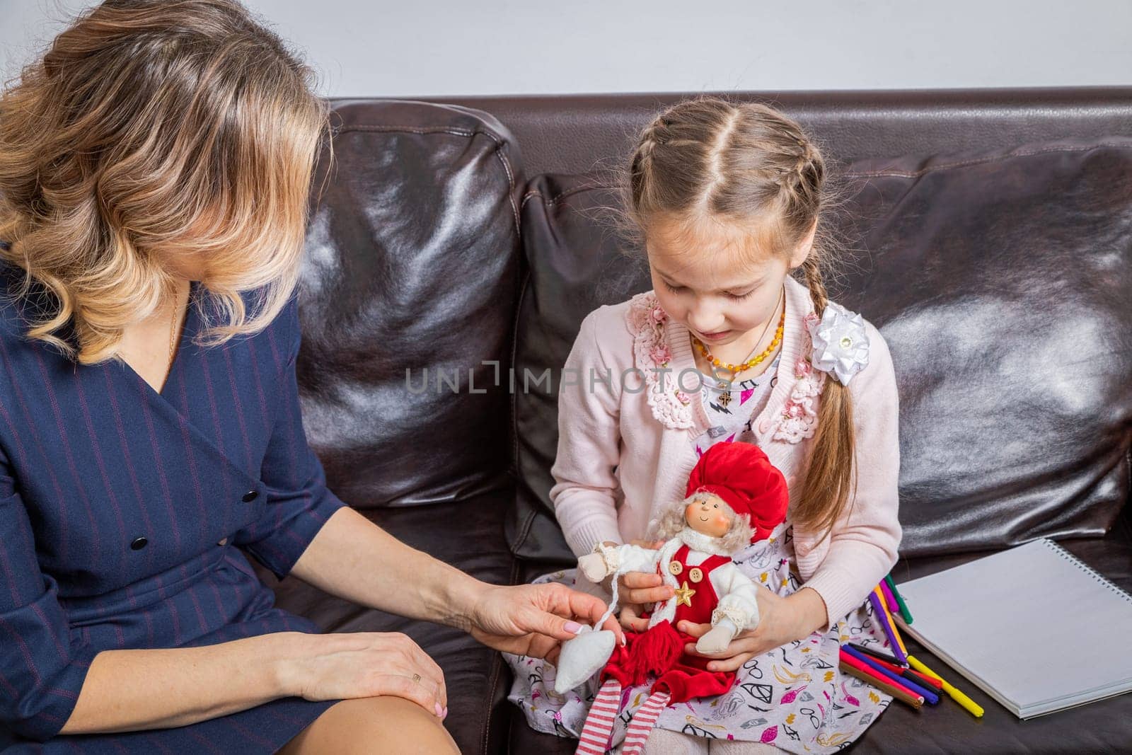 The girl psychologist plays a puppet character game with the child. by Yurich32