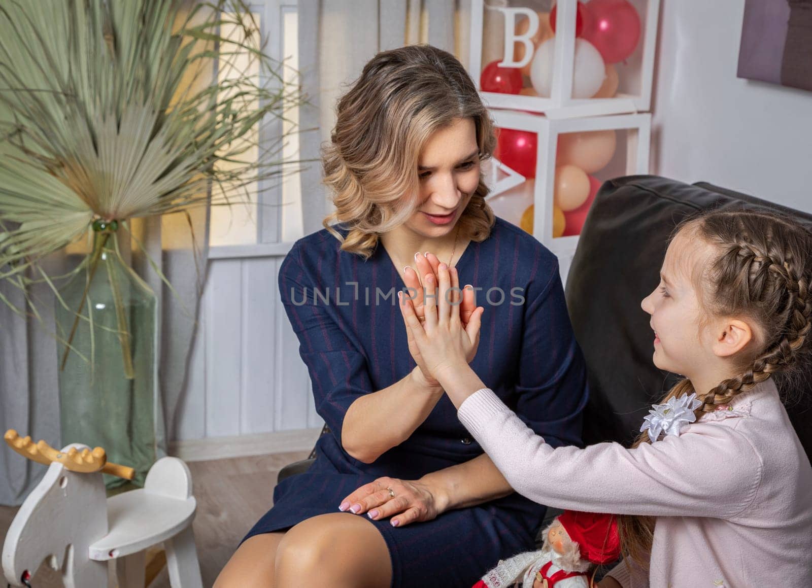 The girl psychologist and the child clap their hands at the successful resolution of the problem