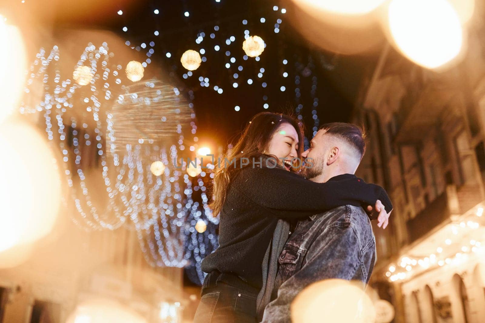 Happy multiracial couple together outdoors in the city celebrating New year.