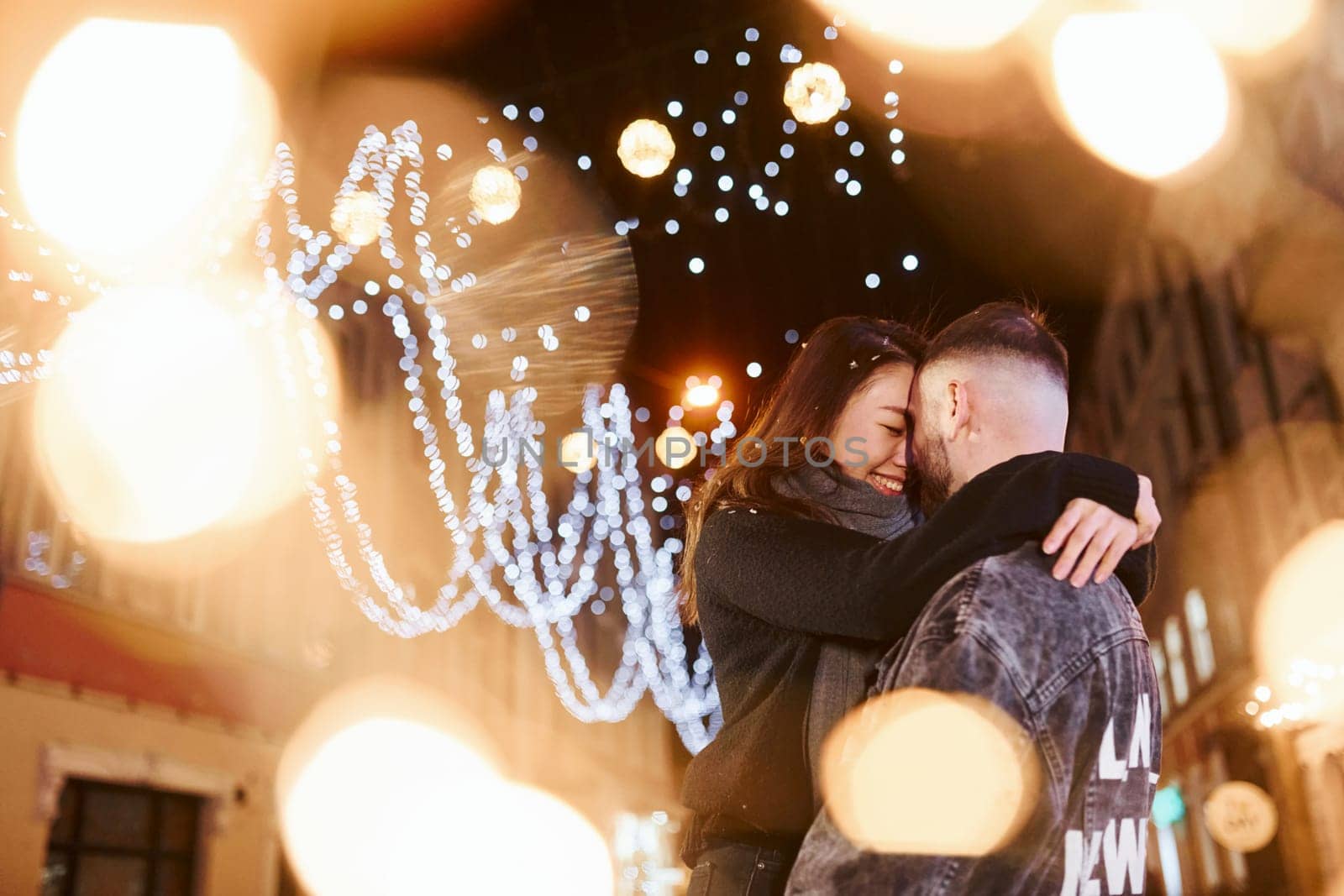 Happy multiracial couple together outdoors in the city celebrating New year.