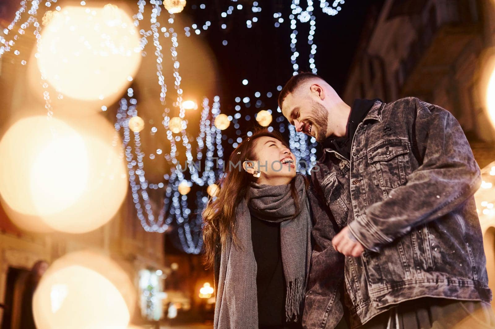 Happy multiracial couple together outdoors in the city celebrating New year.