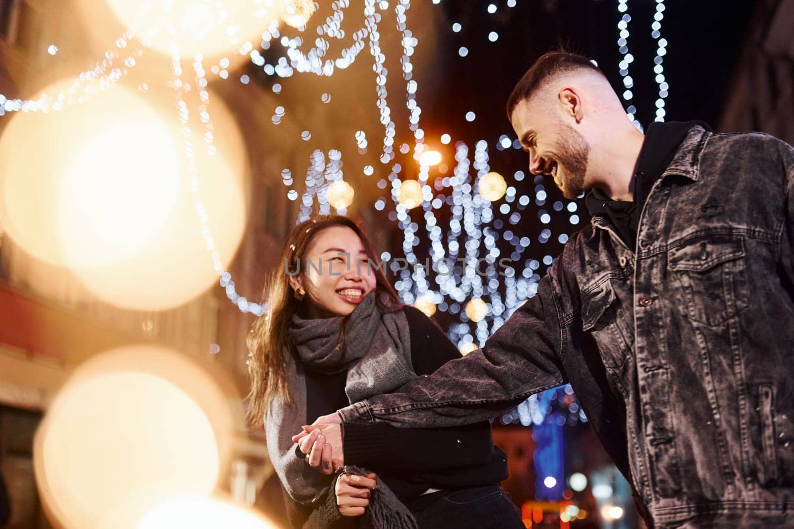 Happy multiracial couple together outdoors in the city celebrating New year.