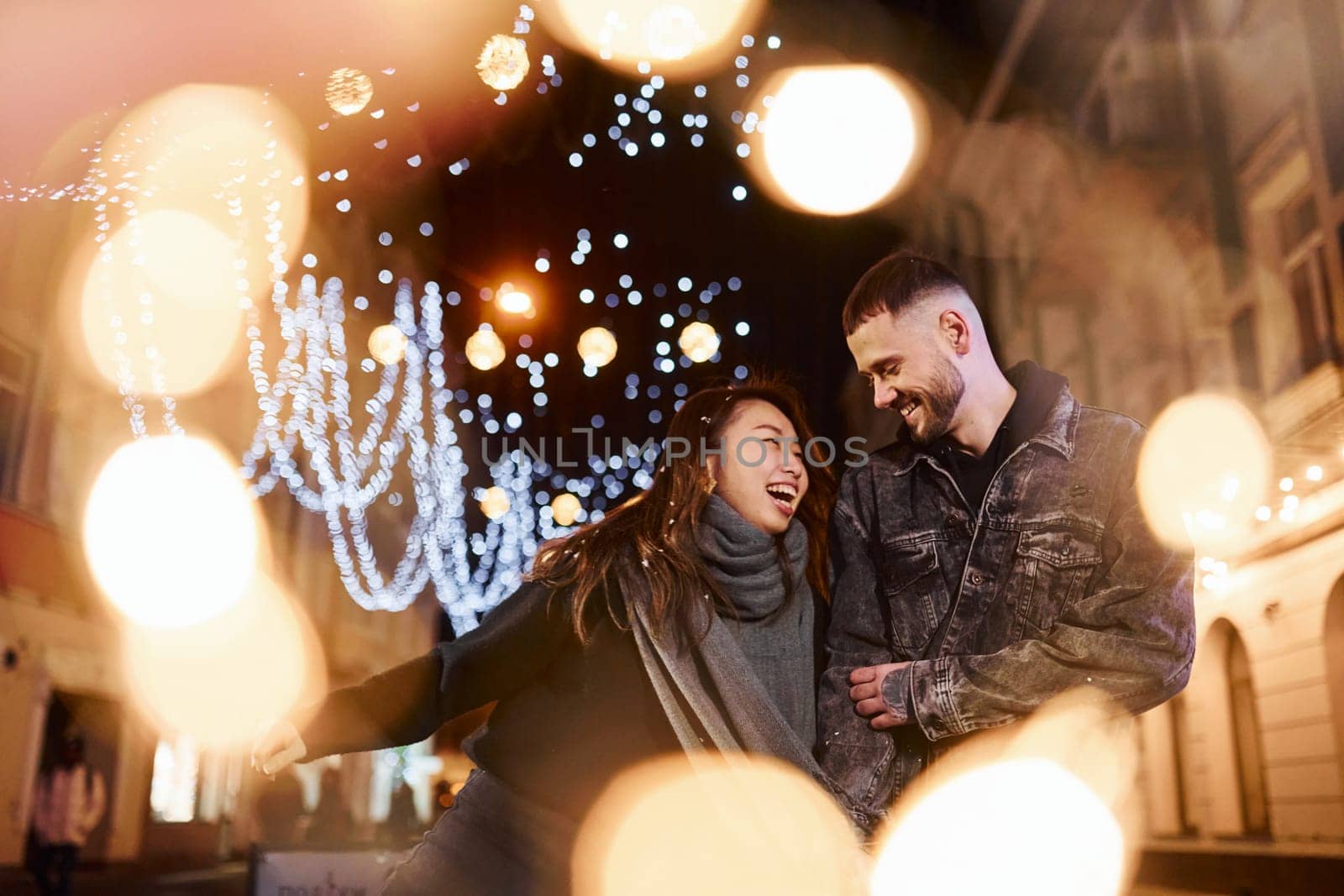 Happy multiracial couple together outdoors in the city celebrating New year.