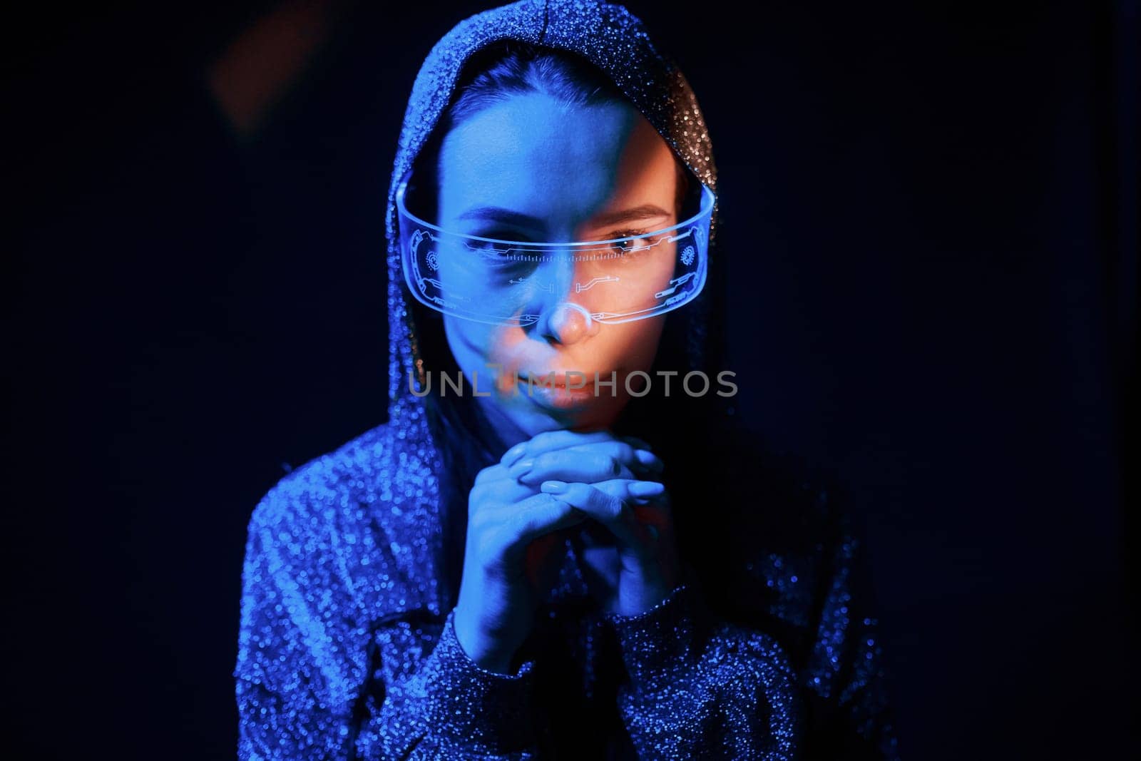 Portrait of young girl that is in eyeglasses in blue neon lighting.