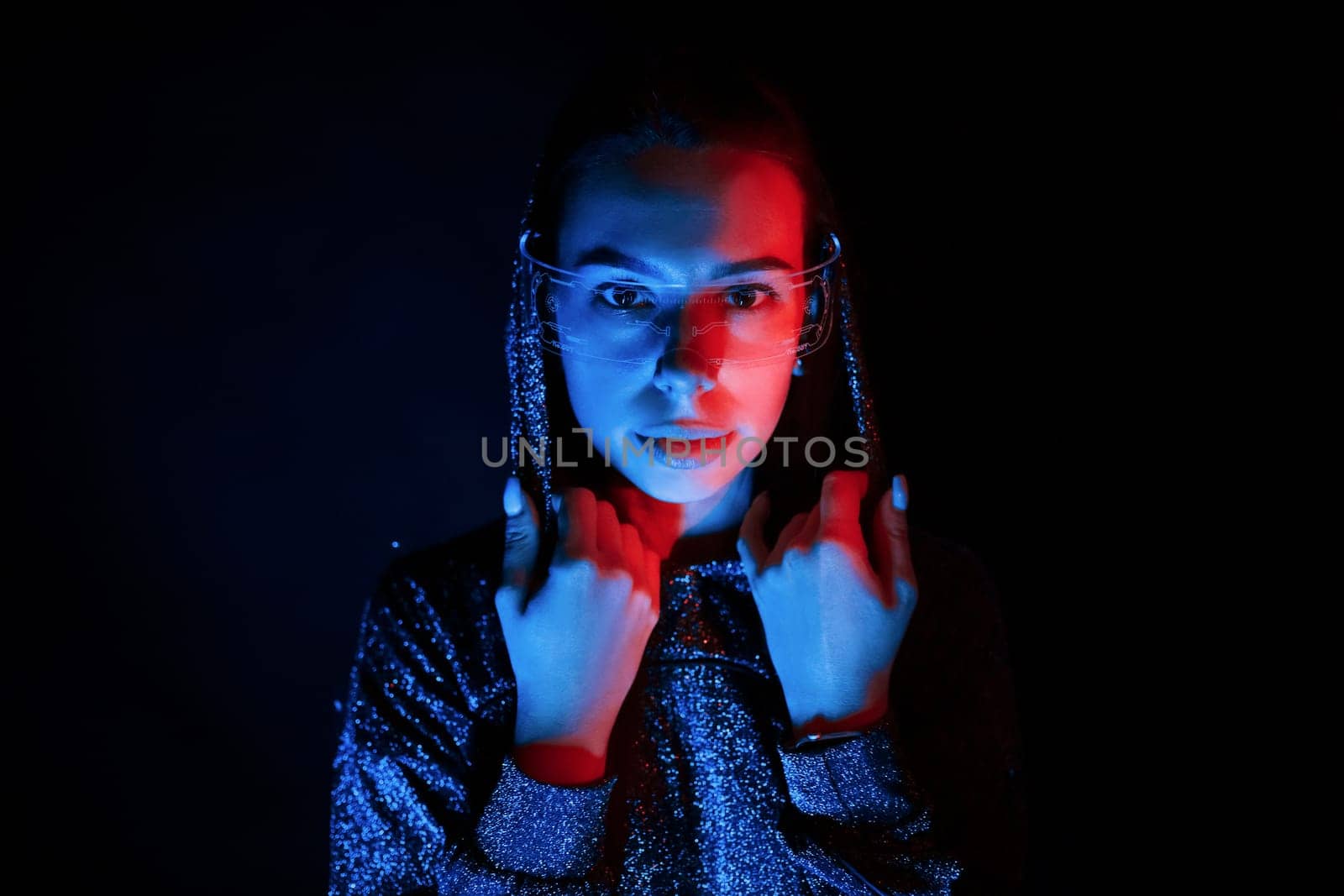 Portrait of young girl that is in eyeglasses in blue neon lighting.