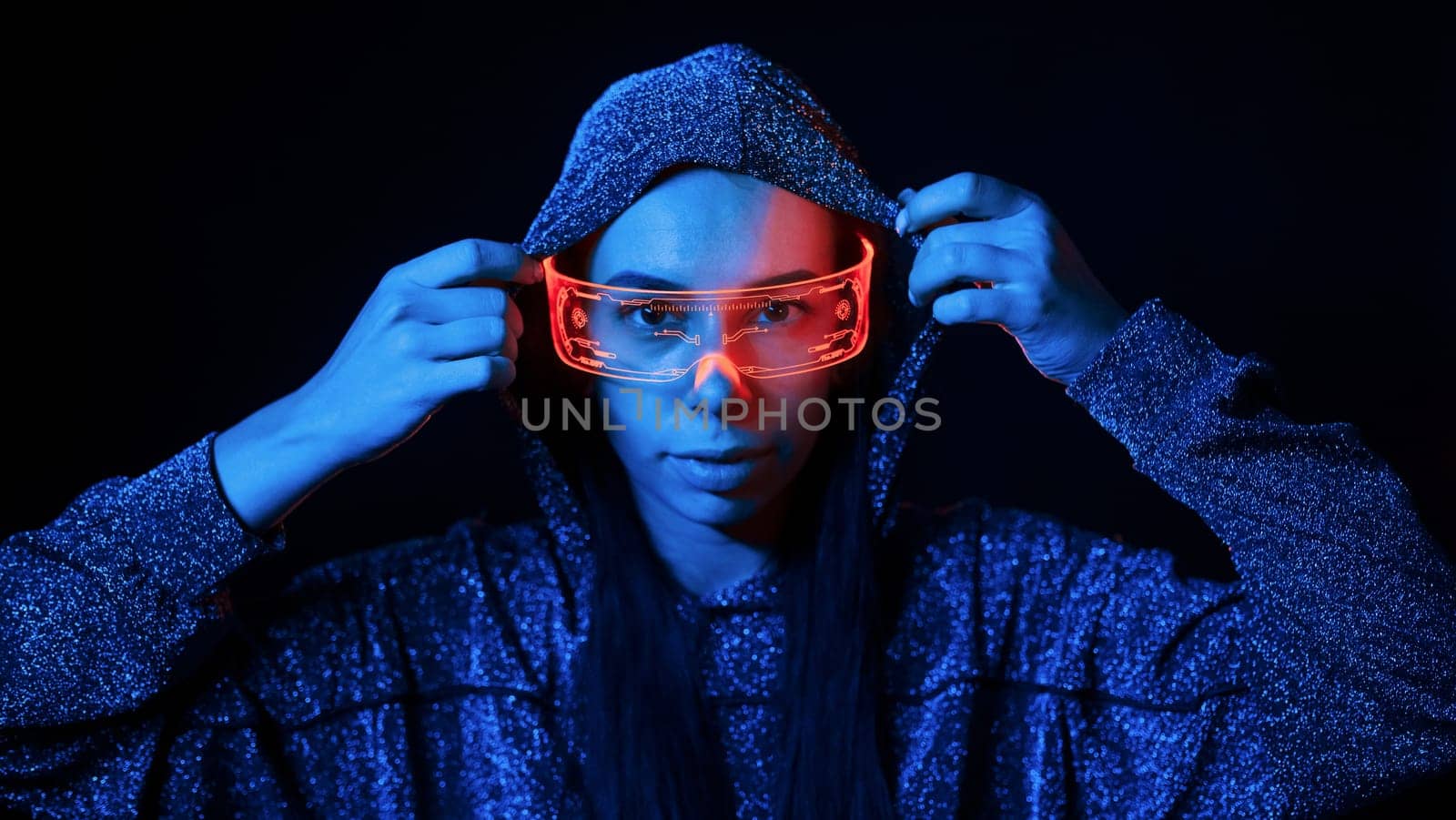 Portrait of young girl that is in eyeglasses in blue neon lighting.