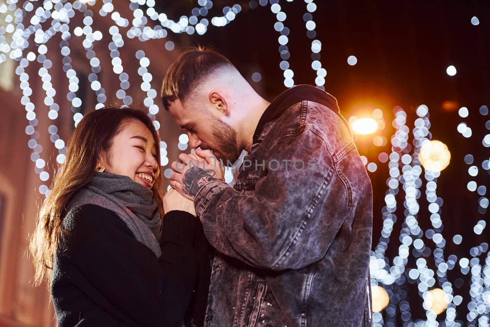 Happy multiracial couple together outdoors in the city celebrating New year.