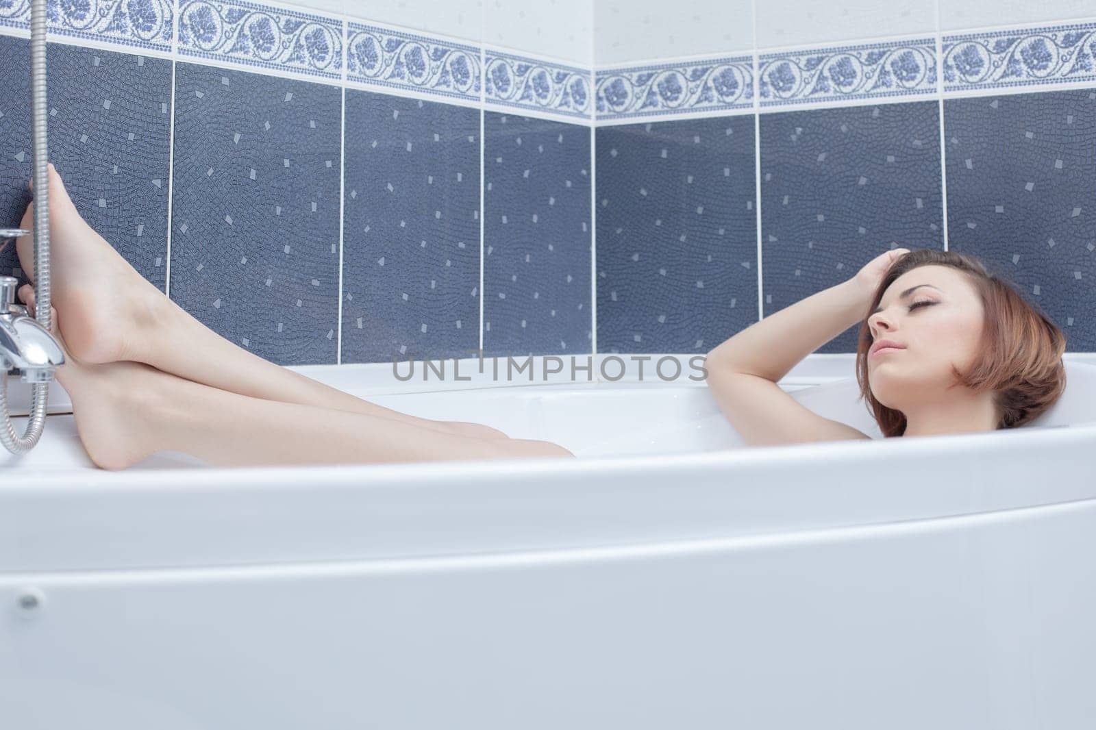 Full length portrait of pretty woman lying in bath