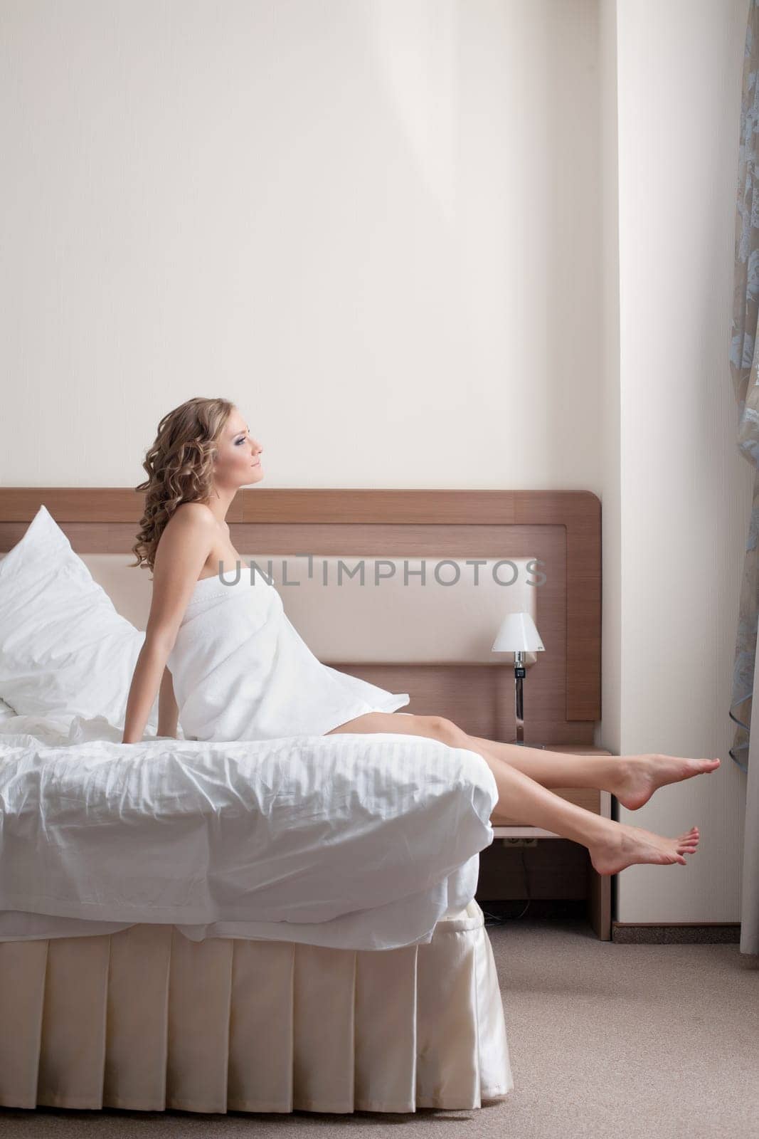sexy blond woman wearing towels on her body stand from bed at morning