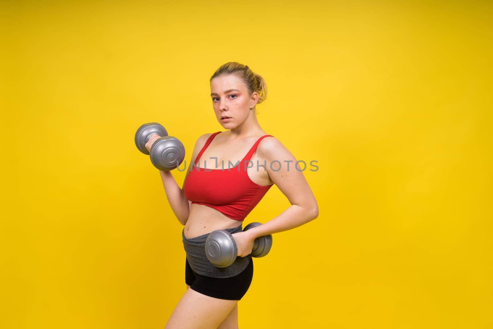 Smiling young plump fitness sporty seductive woman working out doing exercise with dumbbells by Zelenin