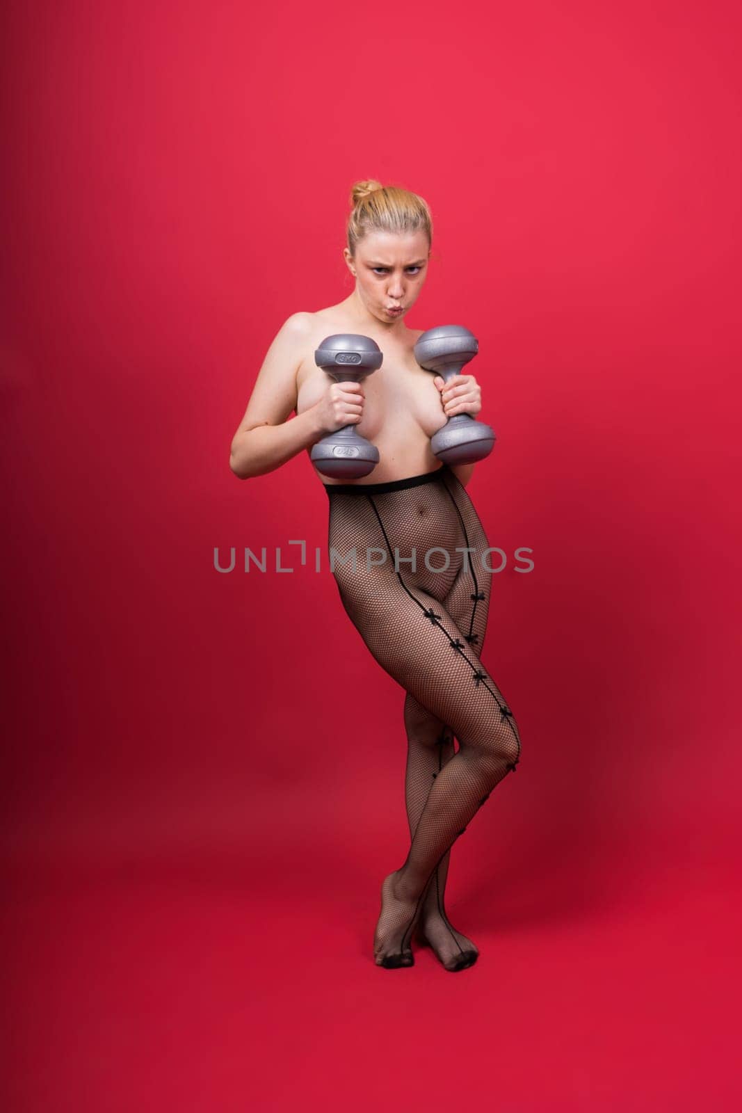 Smiling young plump fitness sporty seductive woman working out doing exercise with dumbbells by Zelenin