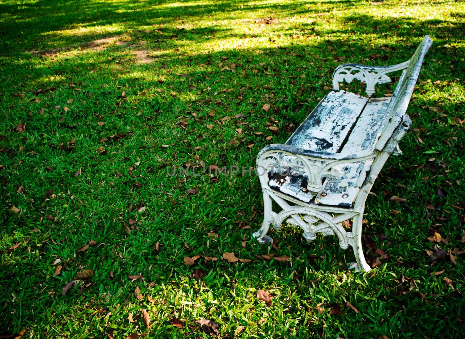 Old white field chairs on the lawn by Satakorn