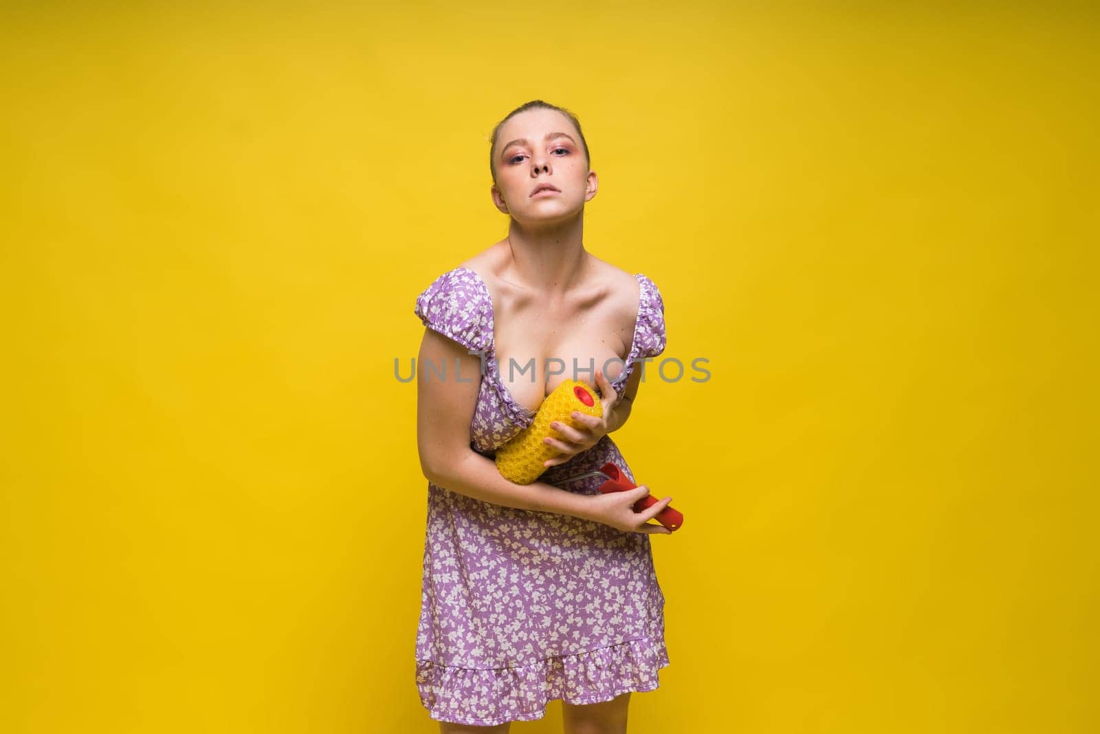 Young classic pin-up woman painting wall with a paint roller