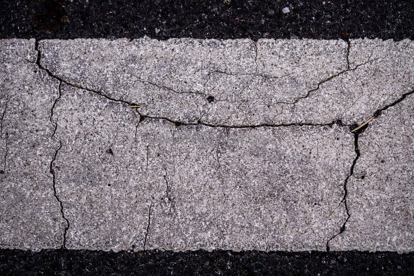 Close-up the cracked on the surface of Road Line painted by Satakorn