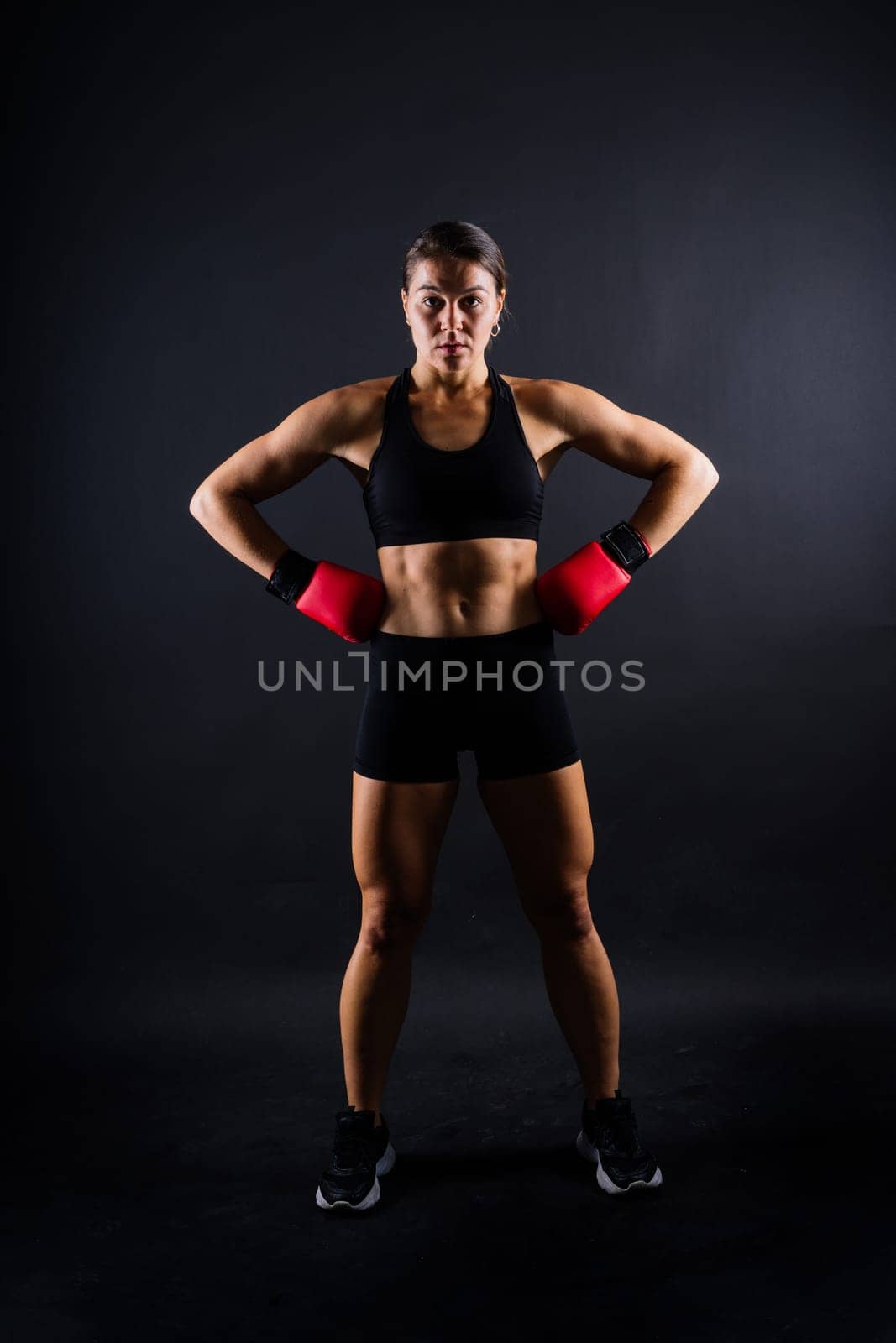 Strong sportswoman in boxing gloves prepared high kick. Isolated on white, red, yellow background by Zelenin