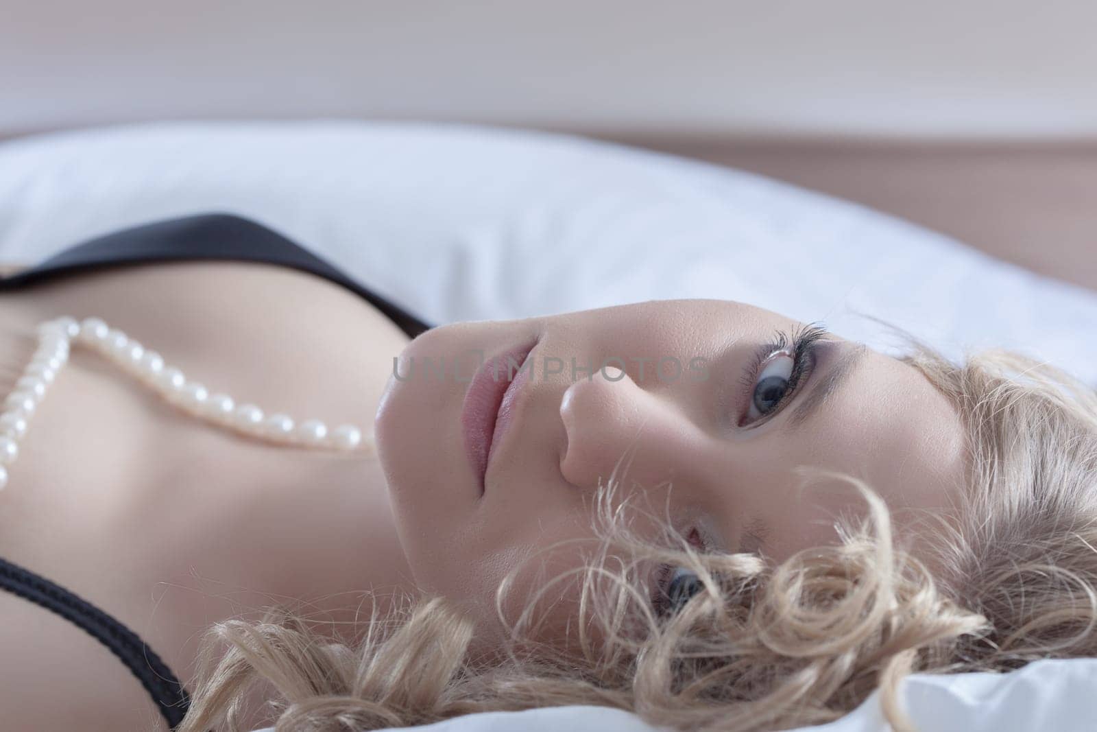 Young beauty woman posing in sexy black lingerie on huge bed of hotel bedroom