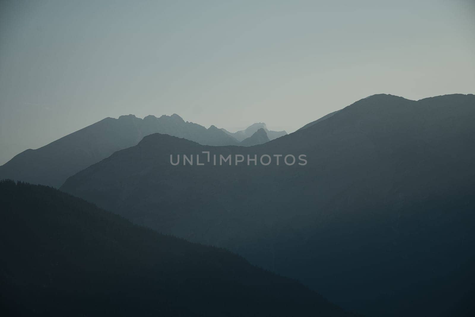 Mountains silhouette with peaks in the morning mist Saalfelden, Salzburg, Austria