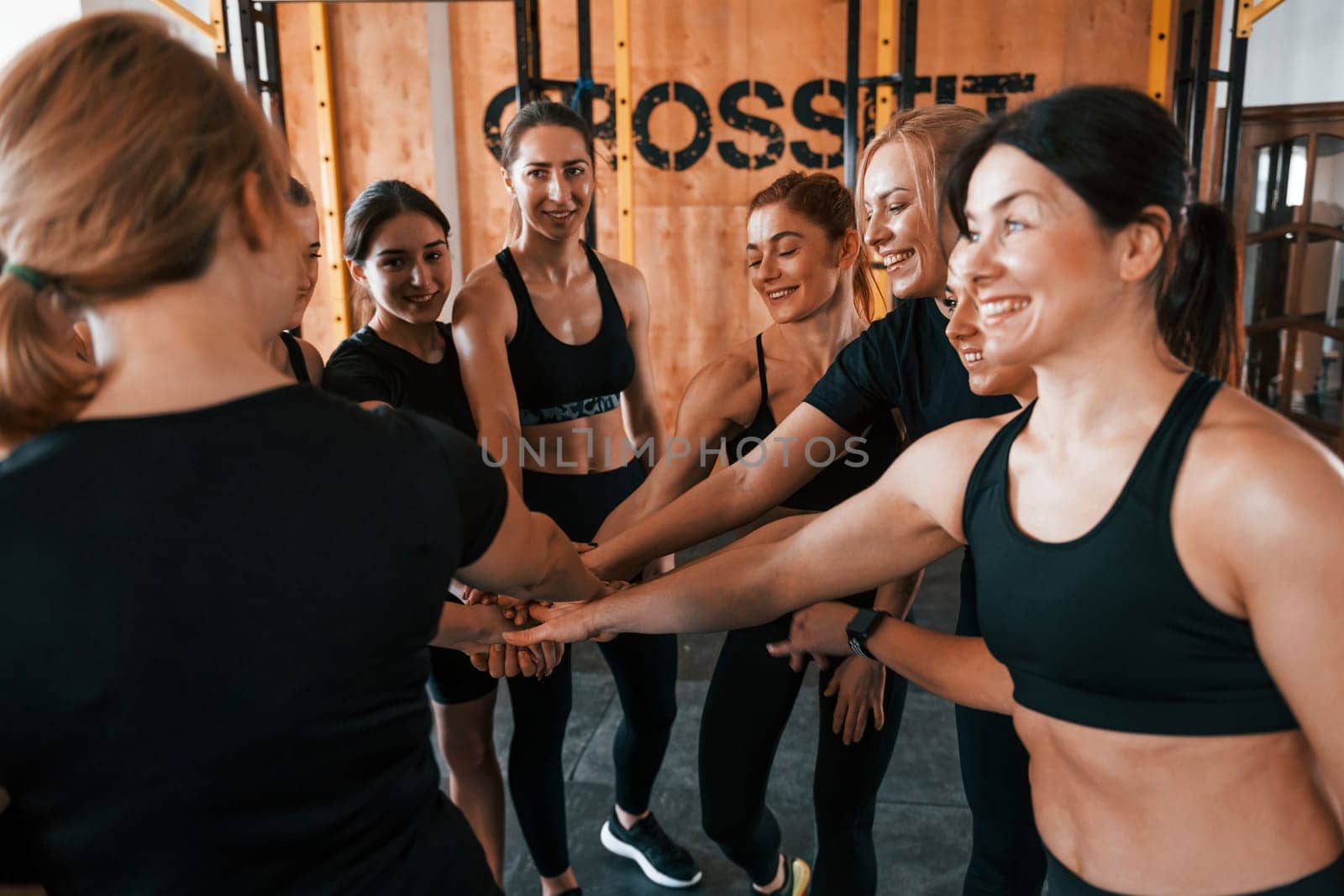 Taking a break. Group of young sportive people have crossfit day indoors in gym.