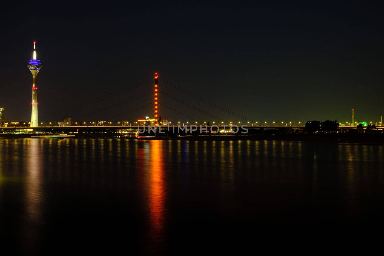 TV tower reflecting on Rhine River at night in Duesseldorf, Germany