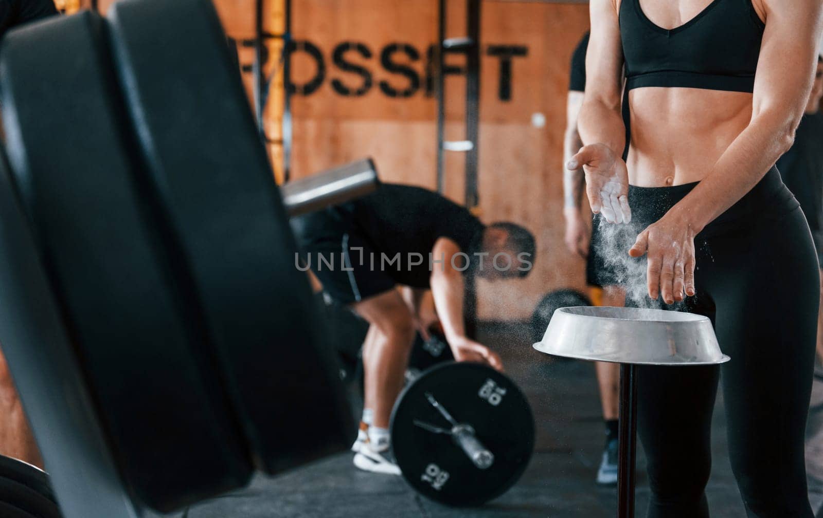 Group of young sportive people have crossfit day indoors in gym.