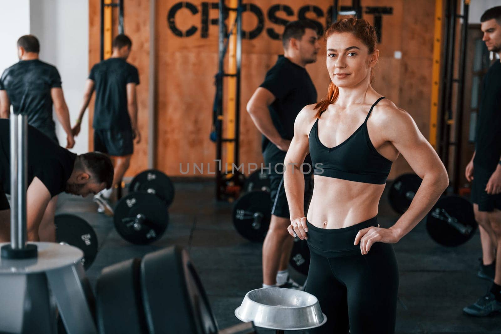 Group of young sportive people have crossfit day indoors in gym.
