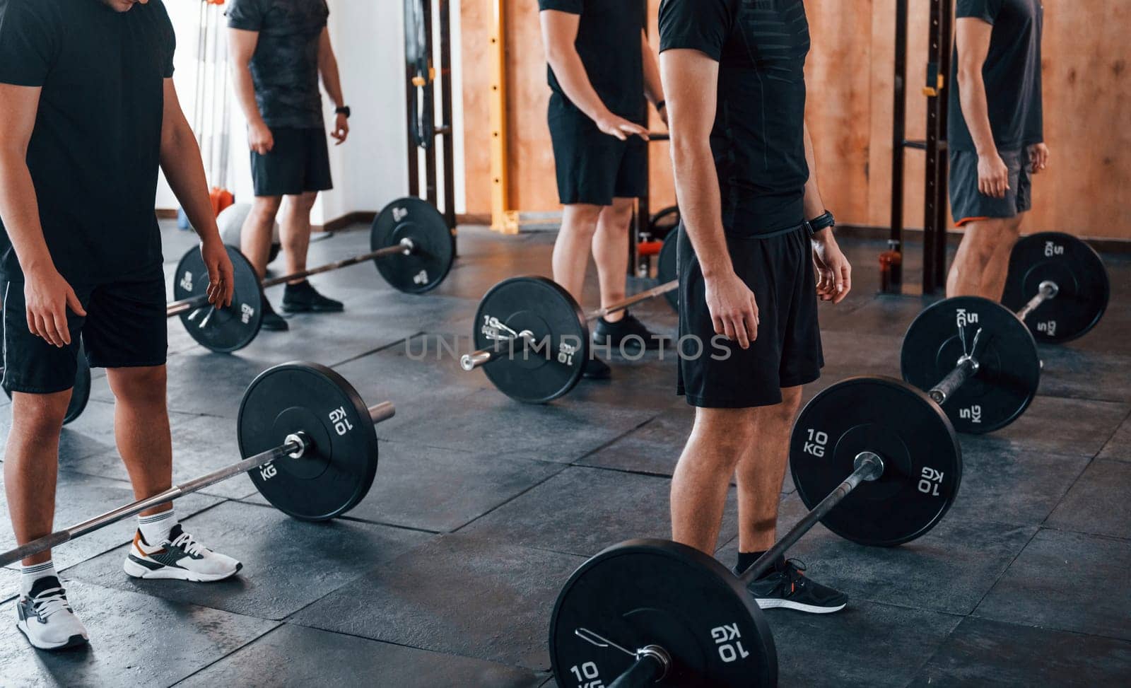 Group of young sportive people have crossfit day indoors in gym.