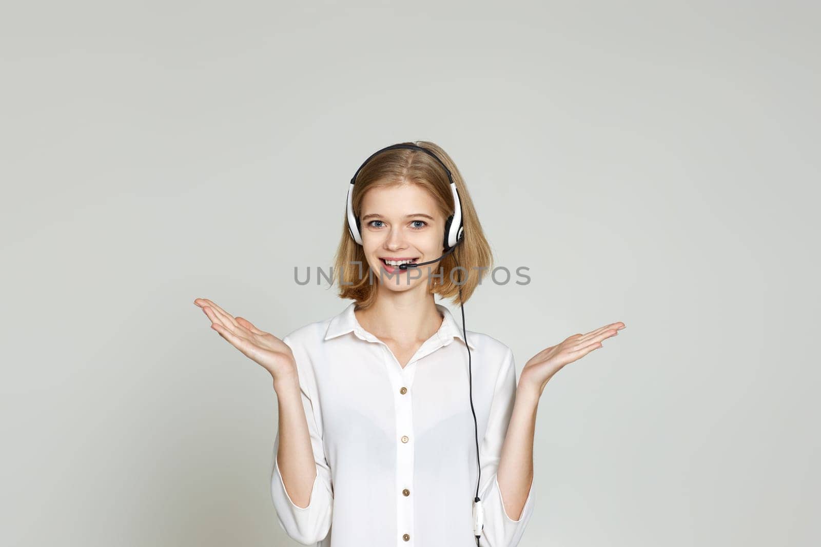 friendly blonde woman with headset is consulting clients online. Call center, business people concept