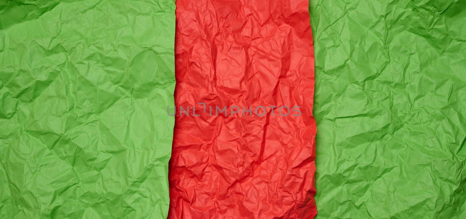 Crumpled red and green paper sheets, paper texture. Background for designers by ndanko