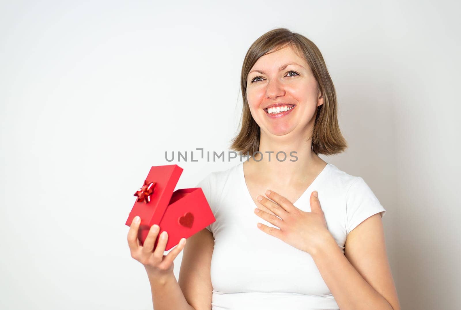 Happy smiling women in white shirt with a red gift box on the white background. by tanjas_photoarts