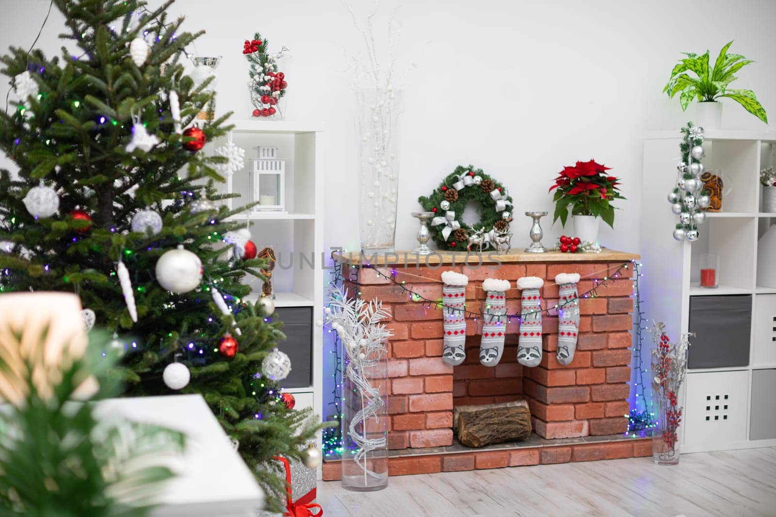 Christmas living room with fireplace and decorations. Christmas tree with baubles.