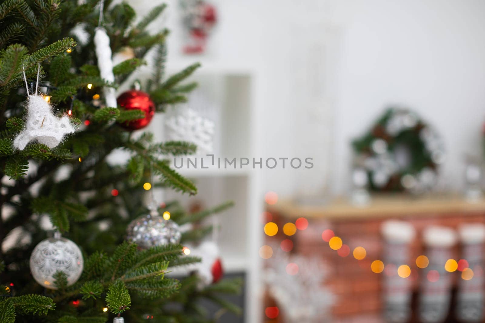Christams tree with handemade decorations. White baubles made of wool.