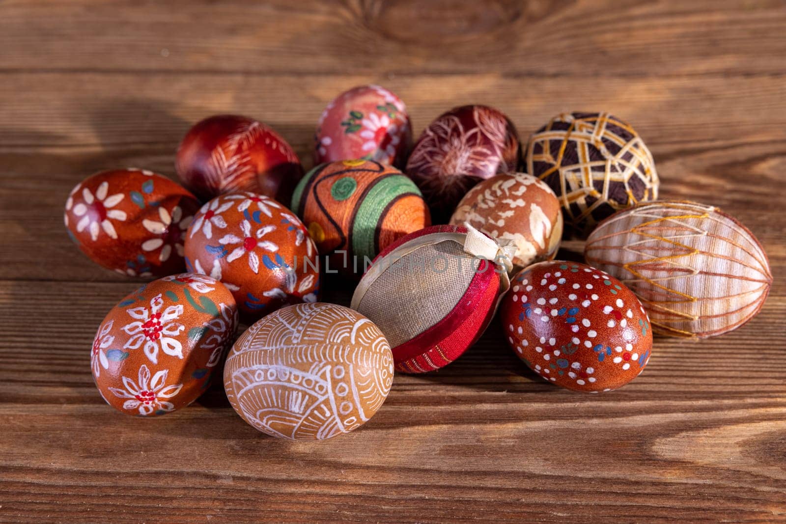 Easter composition of several Easter eggs with brown tones arranged on old brown boards. Blank bowl for adding inscriptions.