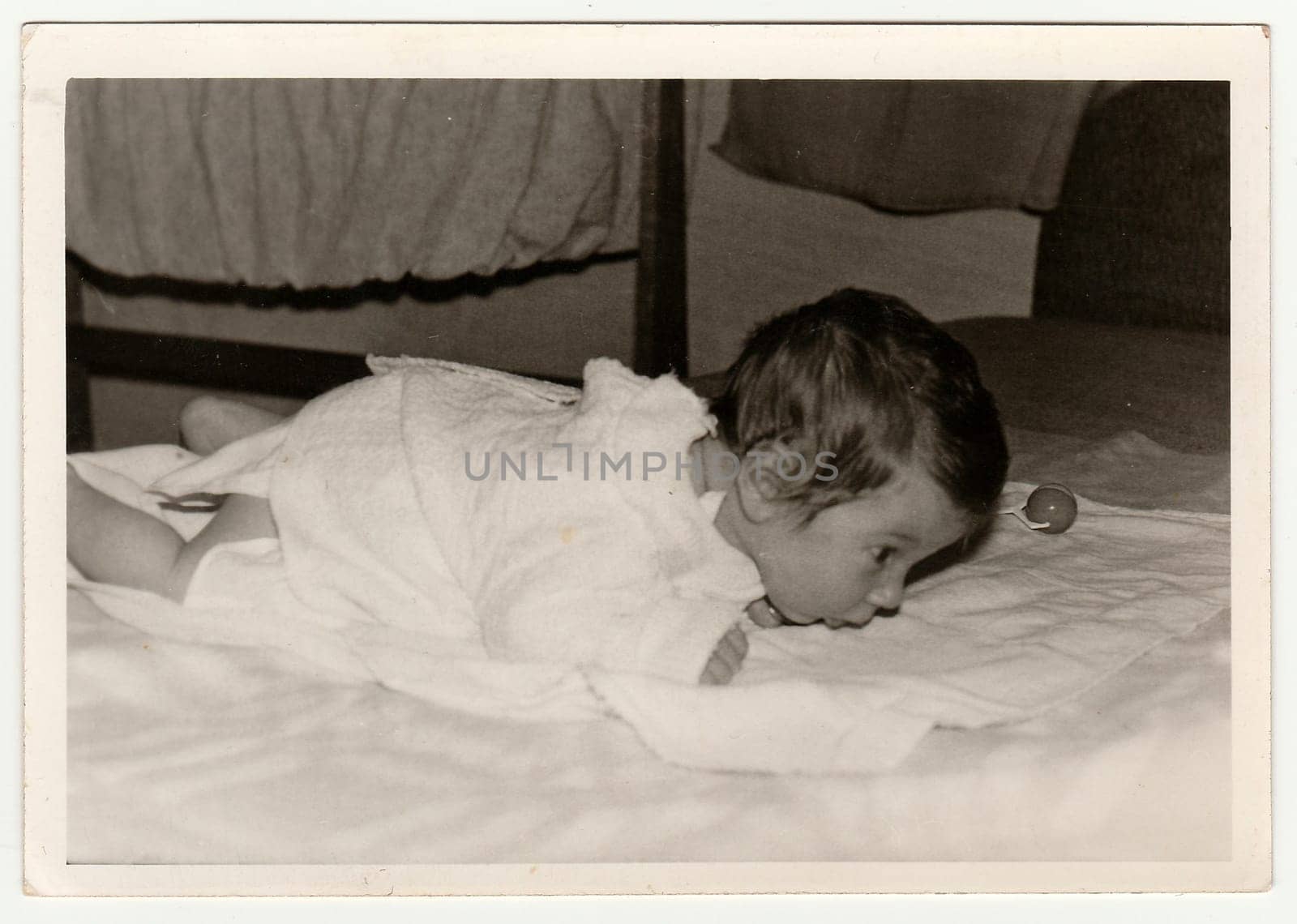 THE CZECHOSLOVAK SOCIALIST REPUBLIC - CIRCA 1970s: Retro photo shows cute baby crawls. Black and white vintage photography.