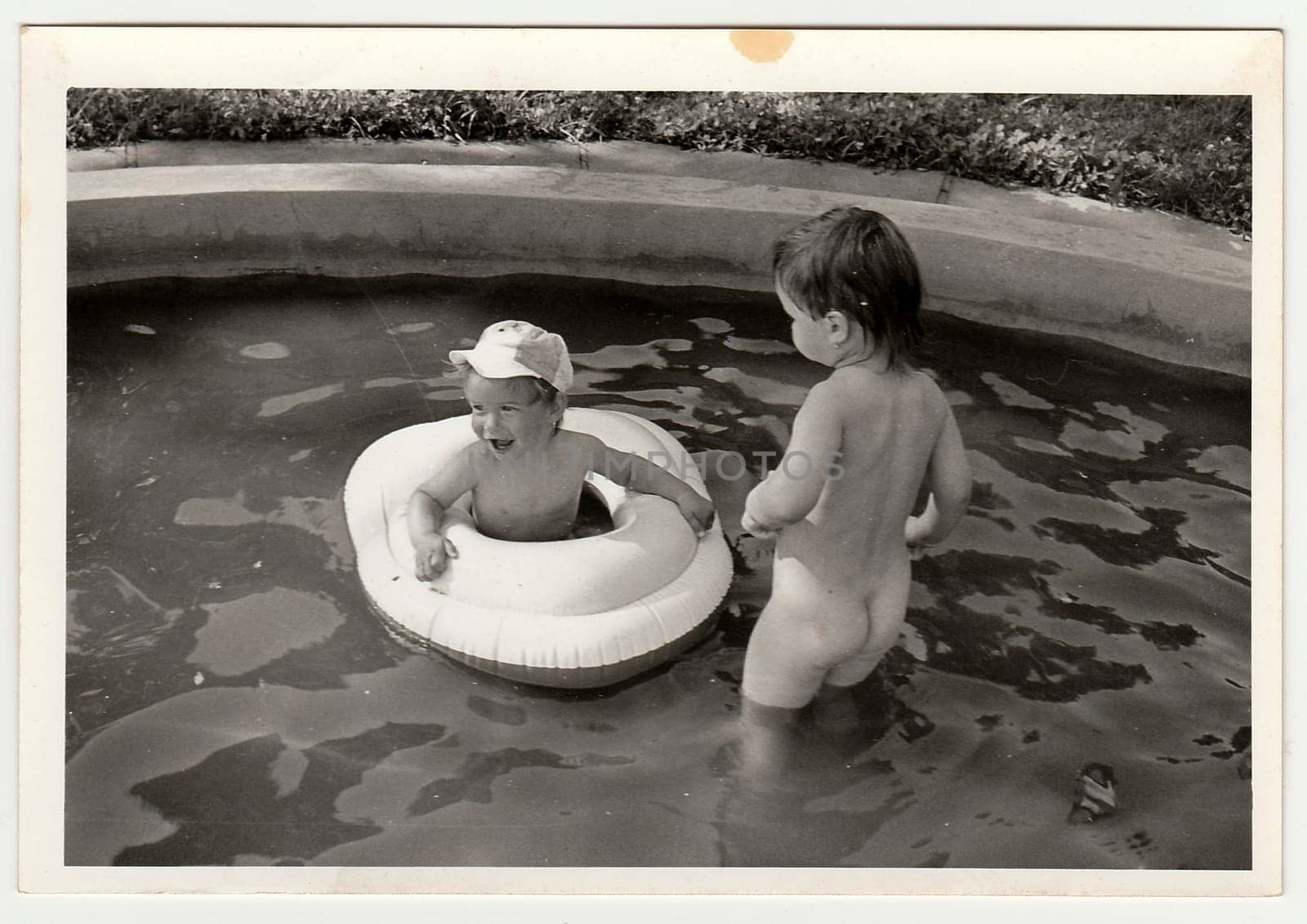 Retro photo shows children in the outdoor pool during summer time. Black and white vintage photography. by roman_nerud