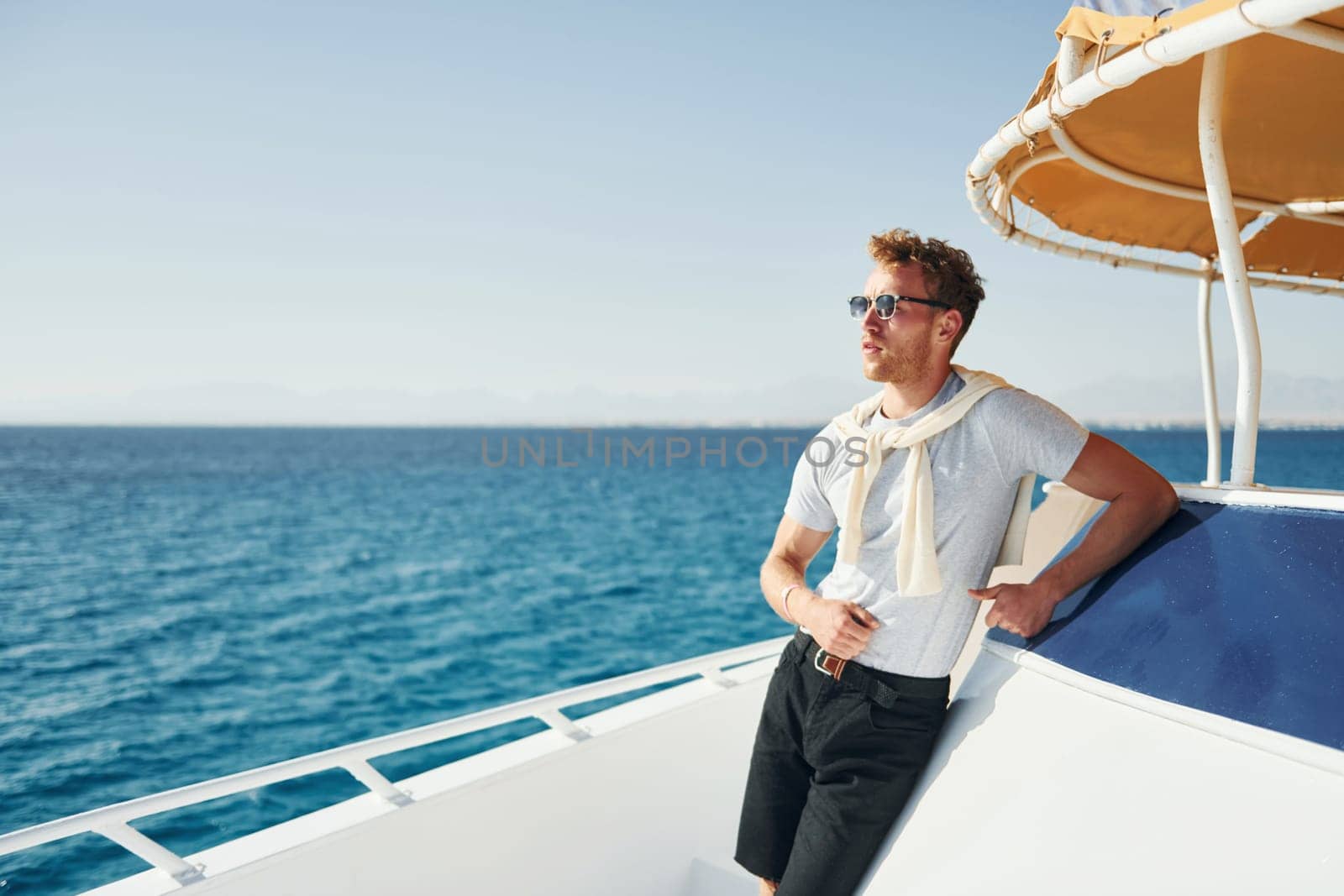 Young male tourist is on the yacht on the sea. Conception of vacation by Standret